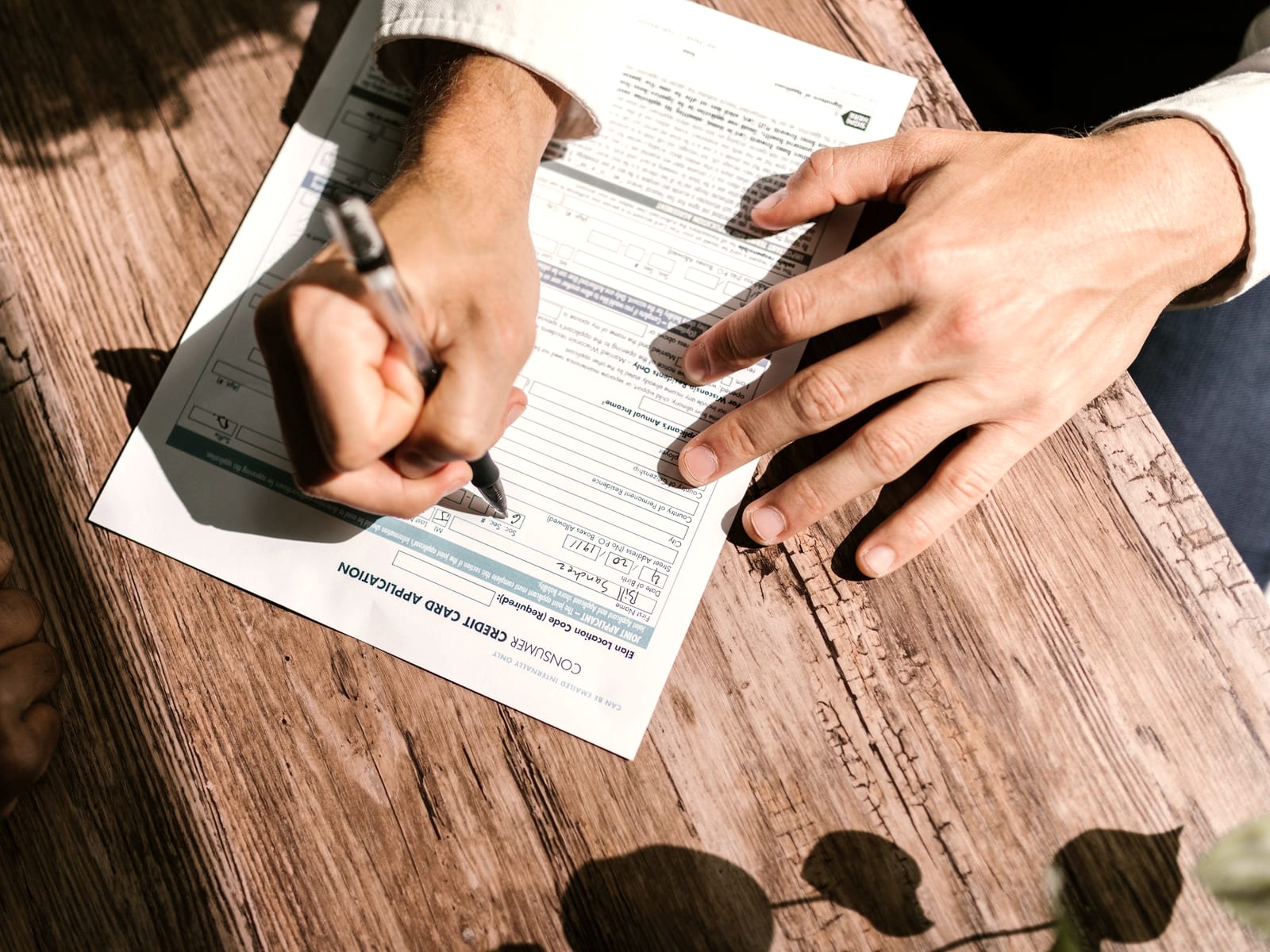 Hands and paperwork on a timber desk
