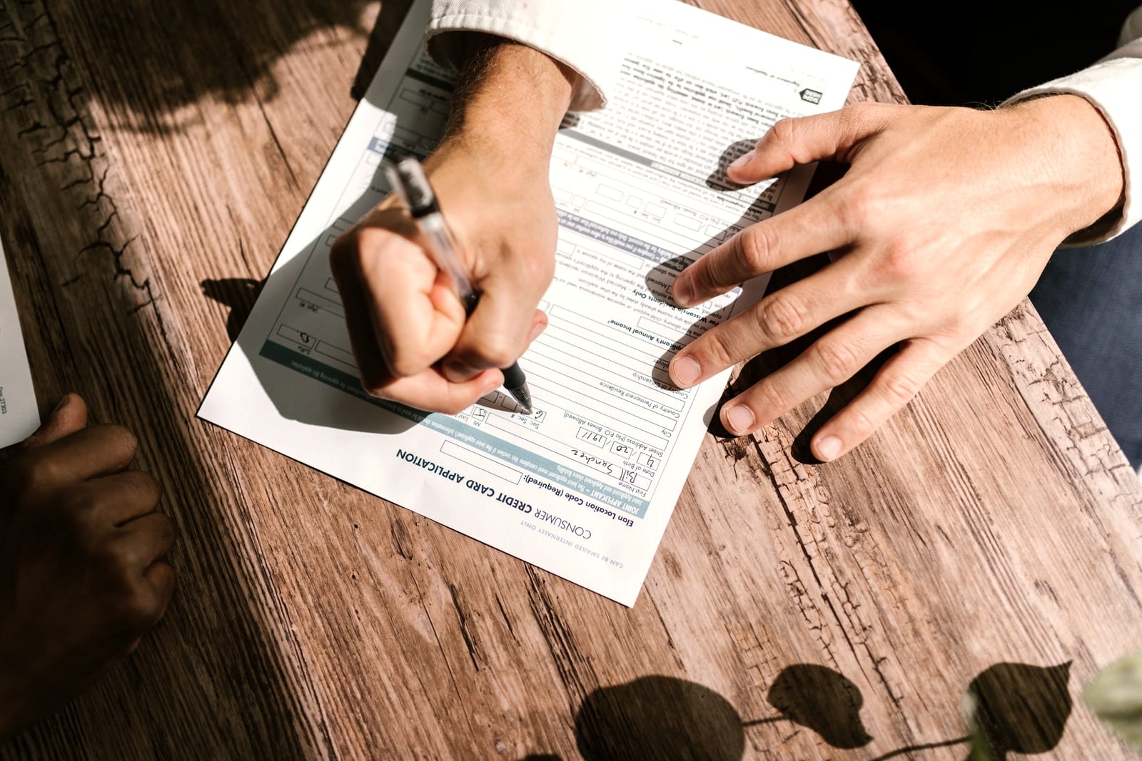 Hands and paperwork on a timber desk